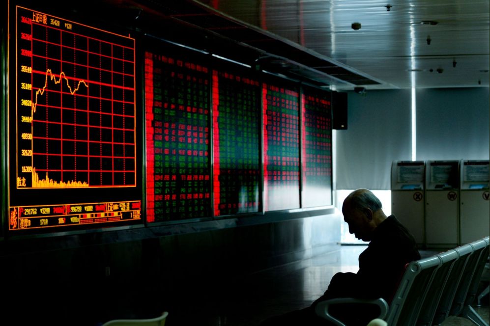 Un inversionista descansa frente a una pantalla que muestra los datos...