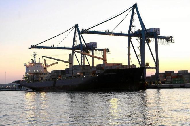 Gras portuarias desembarcando contenedores de un carguero