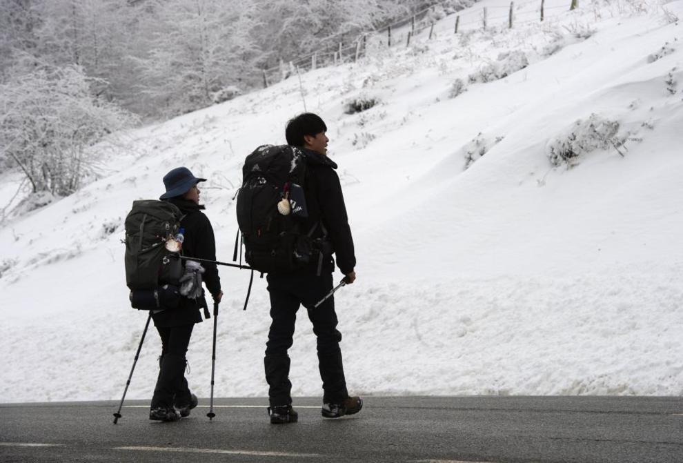 Dos peregrinos llegan al alto de Ibañeta tras una noche de nevadas...