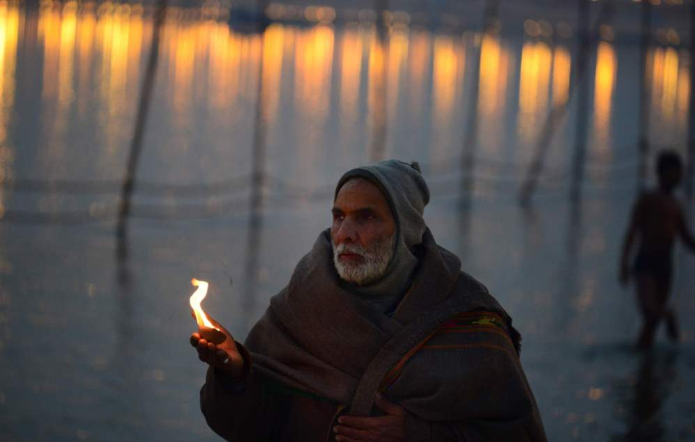 Un hombre hind realiza las oraciones de la tarde en Sangam, en la...