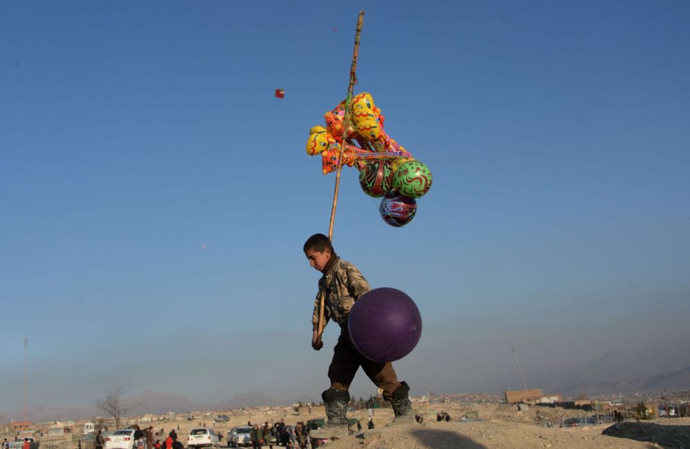 Un vendedor de globos de Afganistn de ocho aos de edad espera...