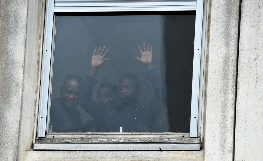 Los refugiados observan a travs de la ventana de un colegio...