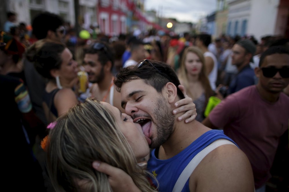 Una pareja se besa durante una fiesta de carnaval en un barrio en...