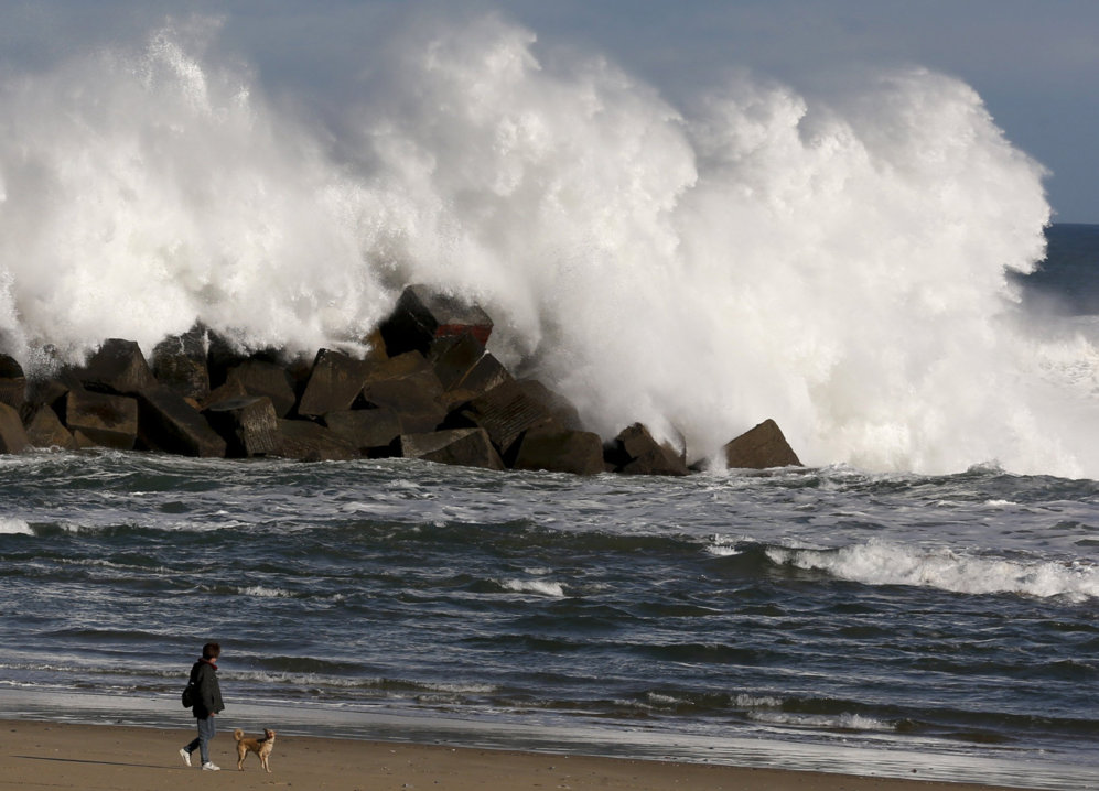 Una gran ola rompe contra el espign de la playa de Zurriola en San...