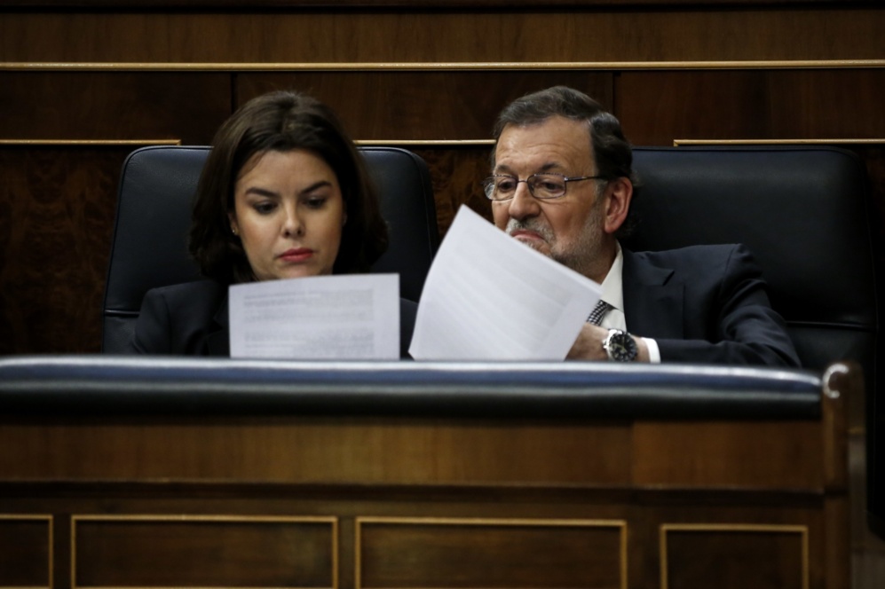 Mariano Rajoy lee unos documentos con Soraya Sez de Santamara.