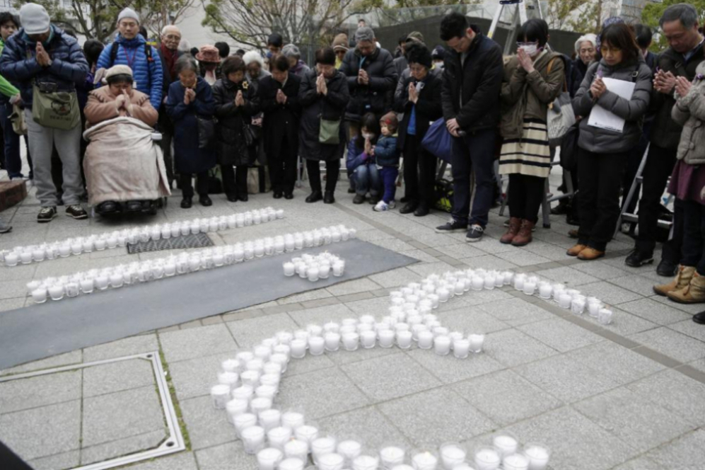 Habitantes de Kobe encienden velas para conmemorar la fecha de la...