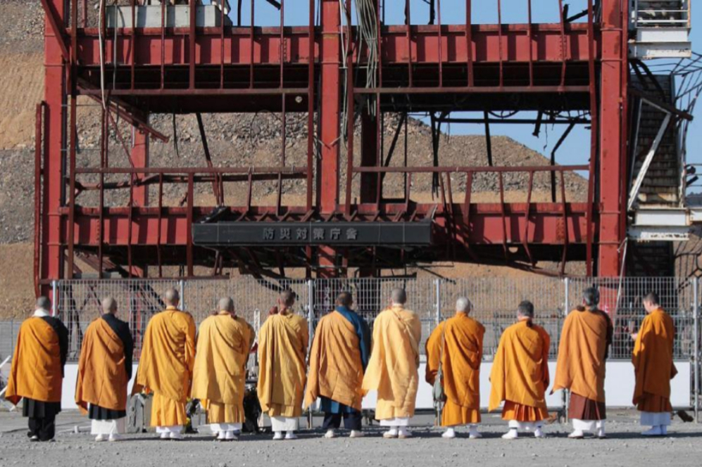 Monjes budistas rezan frente al centro de prevencin de desastres en...