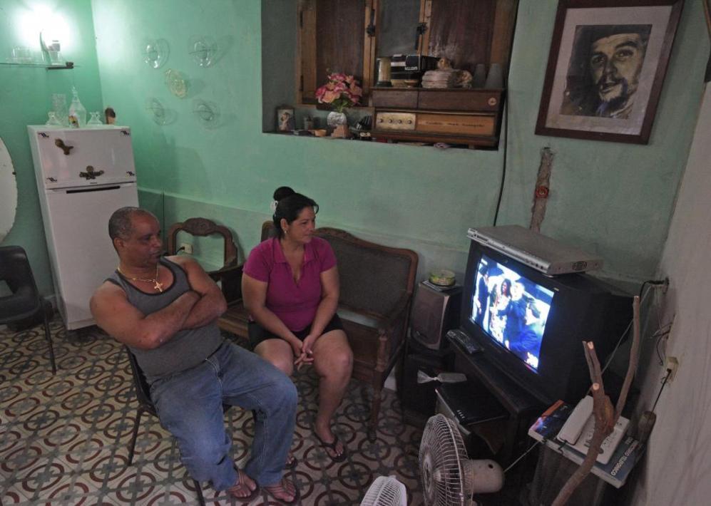 Una familia cubana observa atentamente la llegada del mandatario...