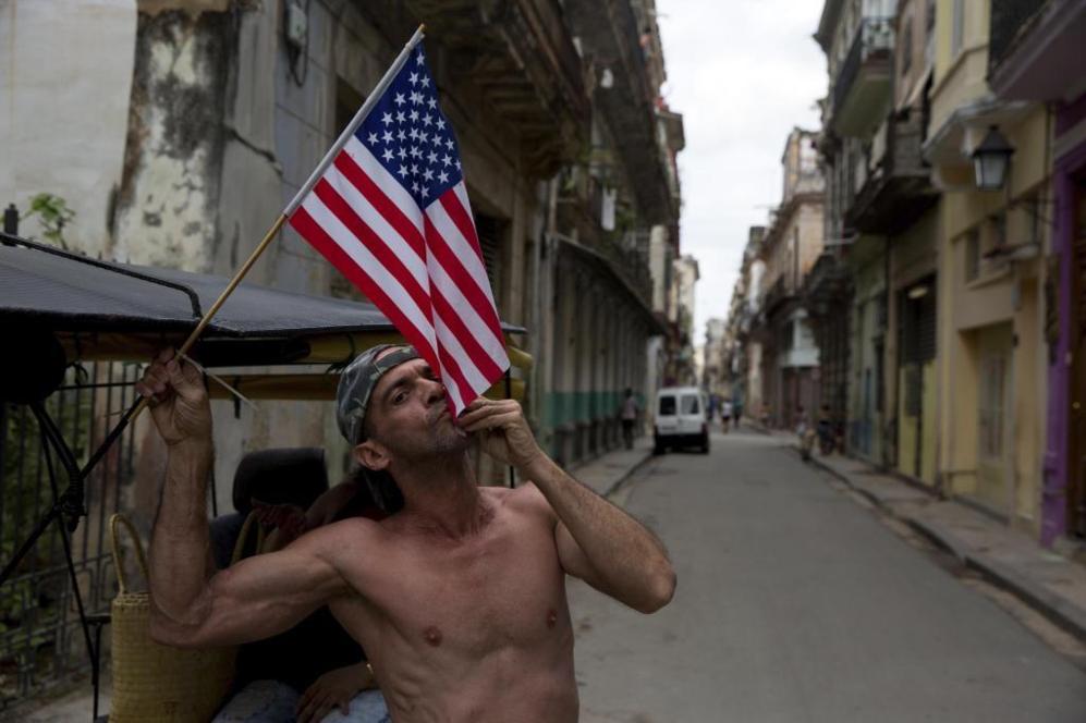 Un cubano besa una bandera de Estados Unidos. La isla se ha preparado...