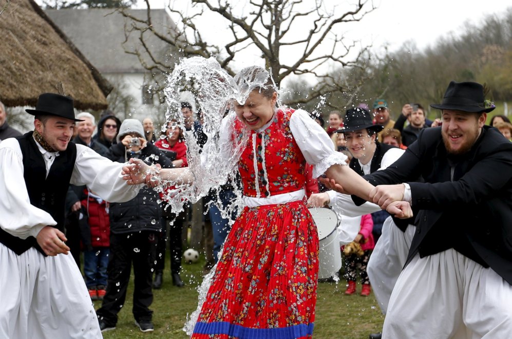 Los hombres lanzan agua sobre una mujer durante las tradicionales...