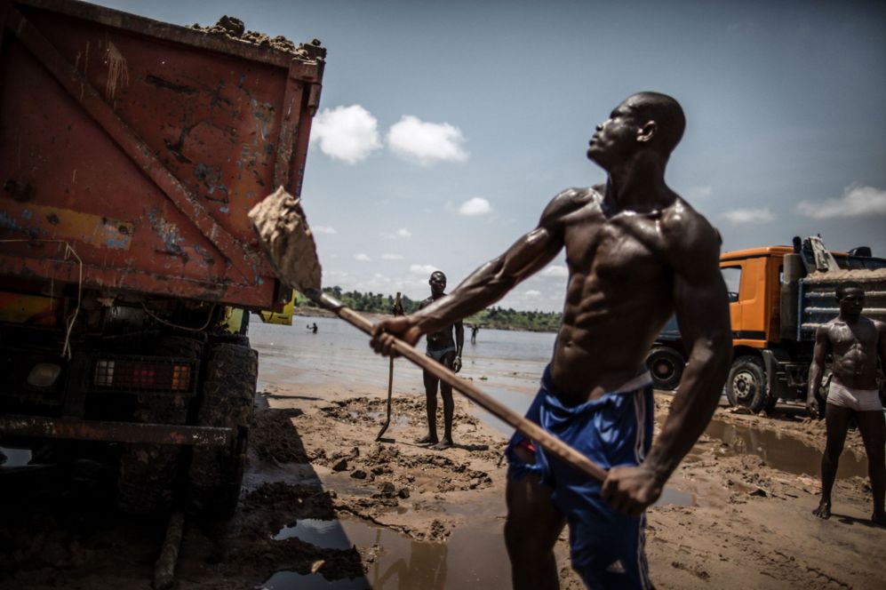 Cavadores de arena cargan en una cantera a las orillas del ro Congo,...