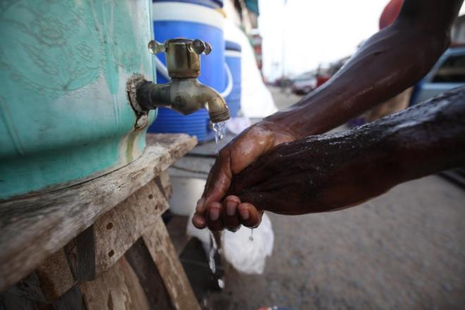 Un hombre liberiano se lava las manos como medida de prevencin.