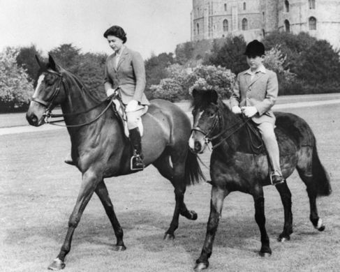 Isabel II y su hijo Carlos montando a caballo en 1961