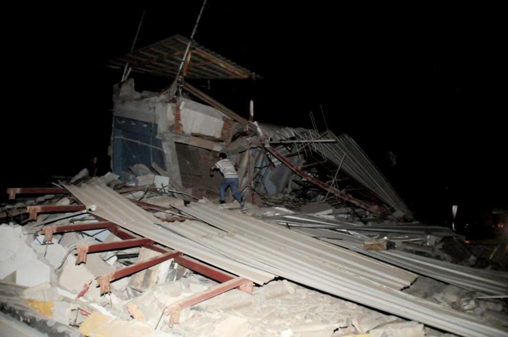 Un hombre  entre los restos de una casa derruida por el terremoto que...