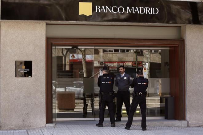 Agentes de la Polica vigilan una de las sucursales de Banco Madrid,...