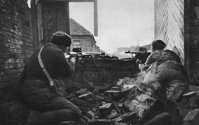 Dos soldados rusos descargan sus fusiles desde una de las barricadas...
