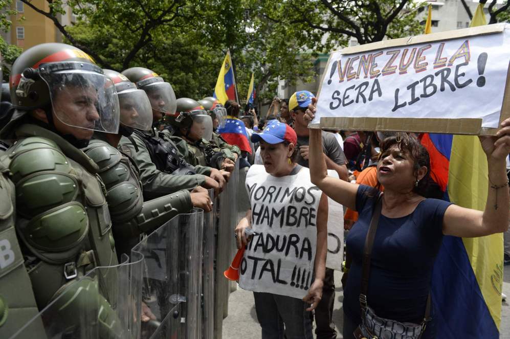 "Morimos de hambre, dictadura total!", reza el cartel que lleva...