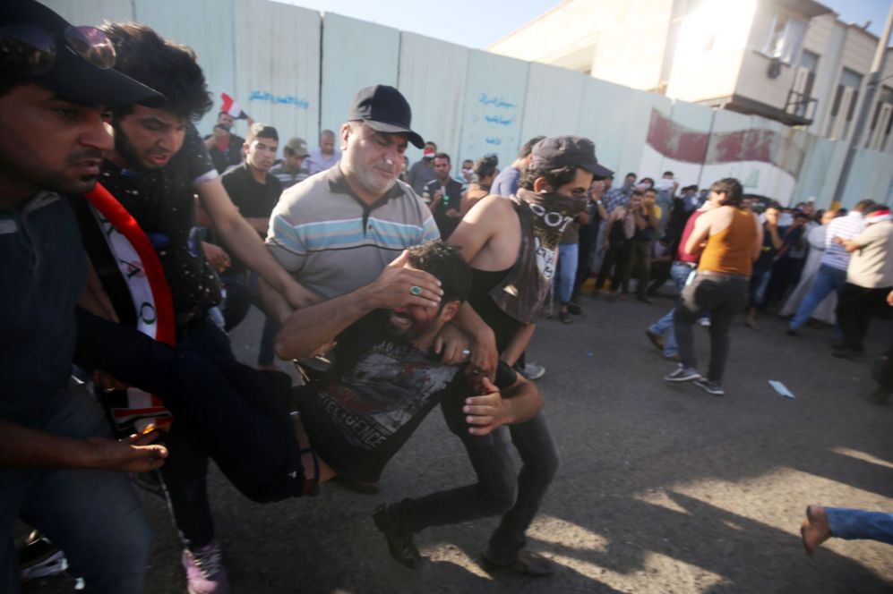 Partidarios de Muqtata al-Sadr ayudan a evacuar a un compaero herido...