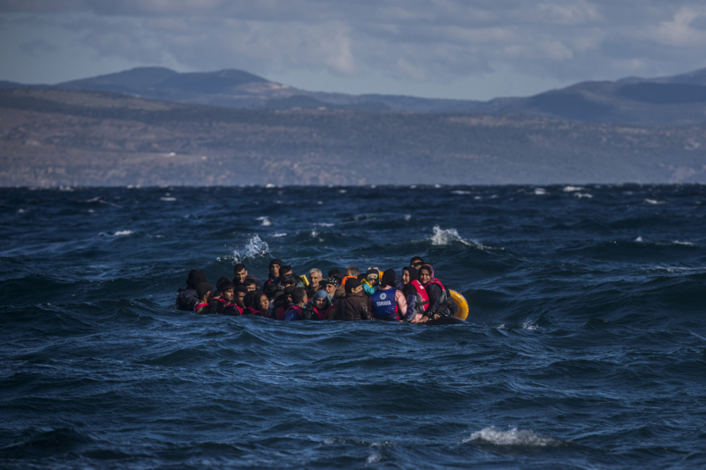 Un grupo de refugiados se aproxima a la isla griega de Lesbos a bordo...