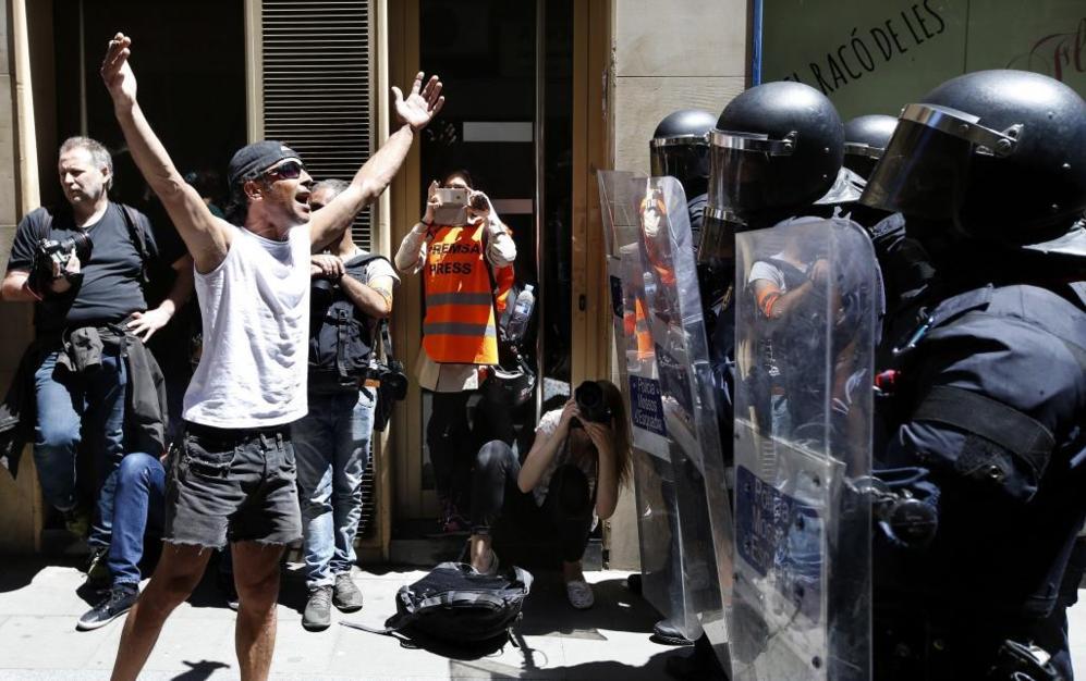 Un manifestante increpa a los antidisturbios de los Mossos d'Esquadra.