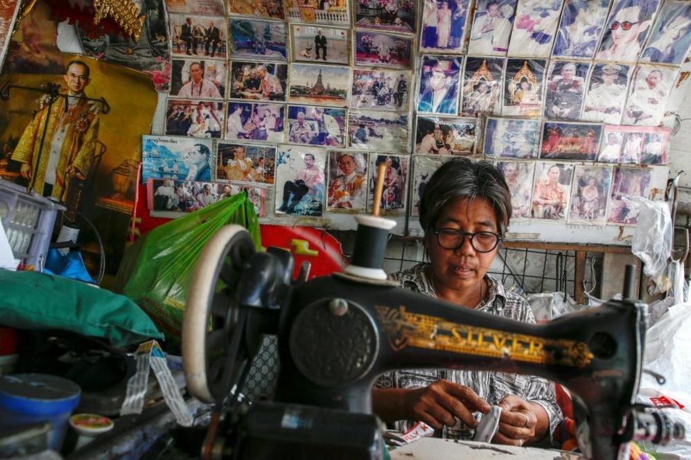 Una mujer trabaja con una mquina de coser enfrente de una pared...