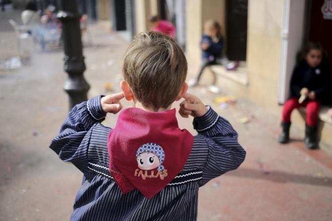 Niño en Fallas se tapa los oídos a la espera de la explosión.