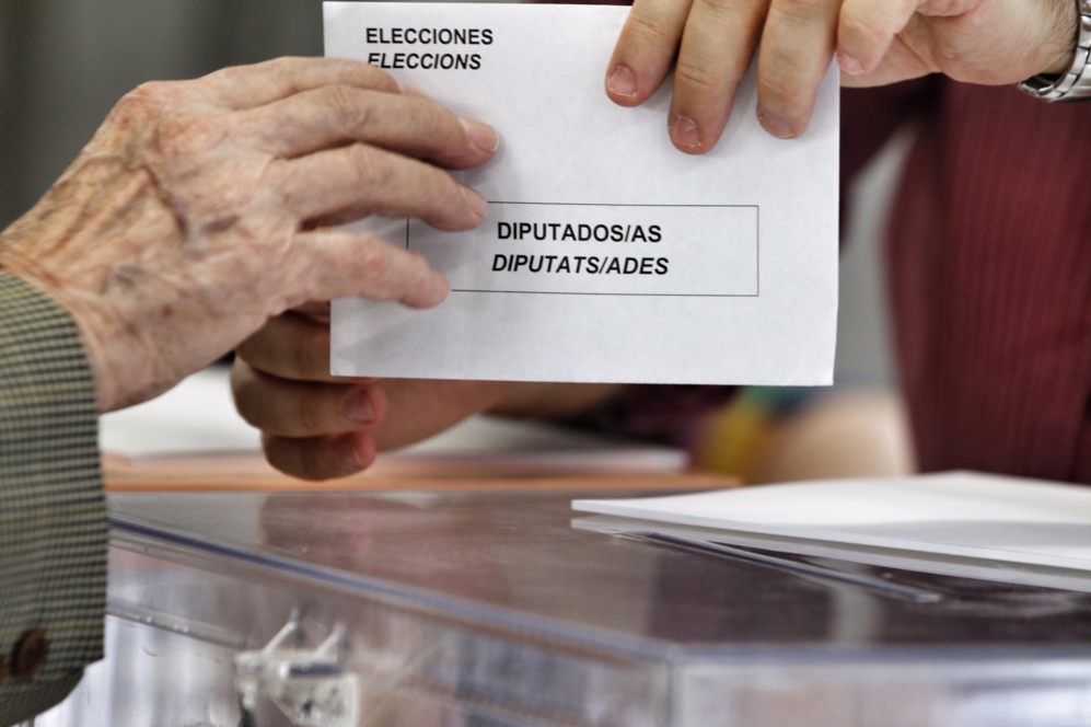 Una persona de avanzada edad deposita sus votos en Alicante.