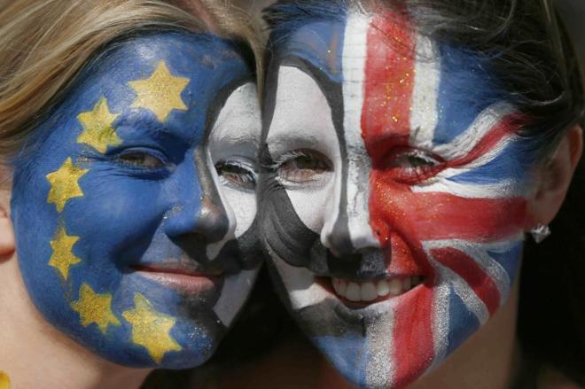 Dos mujeres con las caras pintadas con las banderas europea y...
