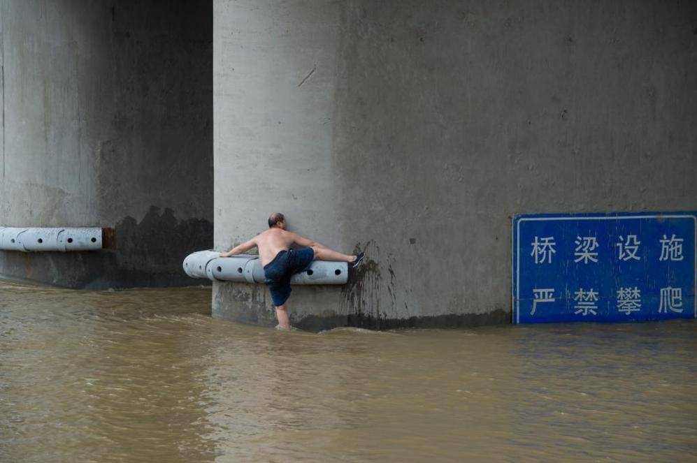 Un hombre trata de salir del agua en las cercanas al ro Yangtze en...