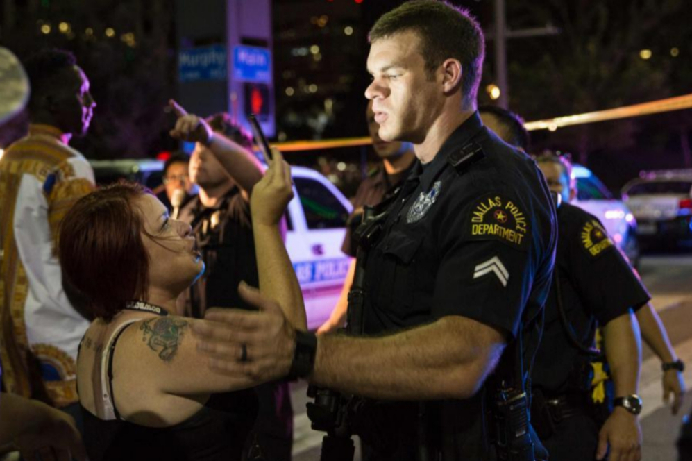 Una mujer graba a uno de los policías que trata de mantener el orden...