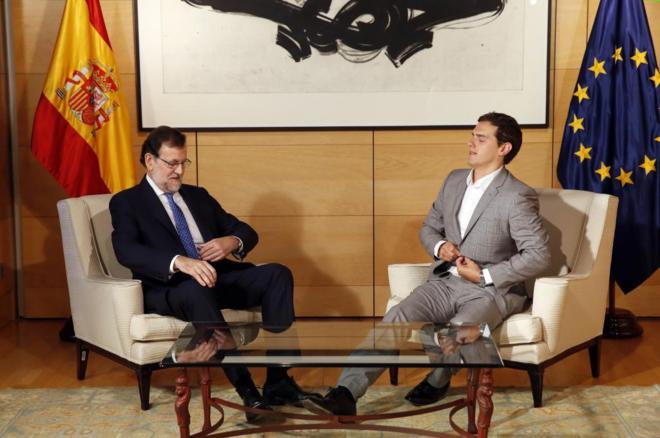 Mariano Rajoy y Albert Rivera se abrochan sus chaquetas durante su...