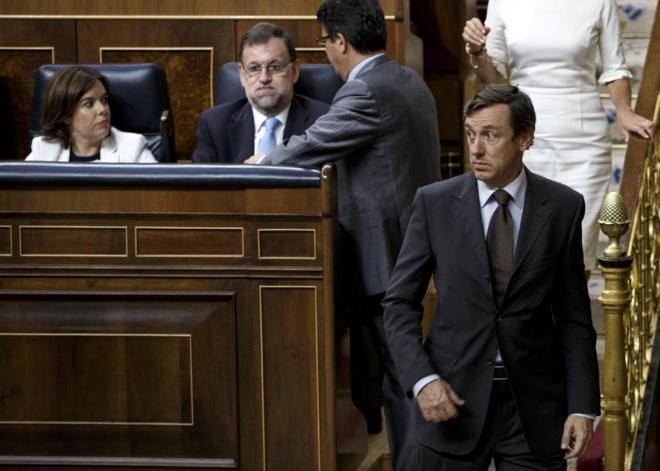 Rafael Hernando pasa delante de Mariano Rajoy durante el Pleno de...