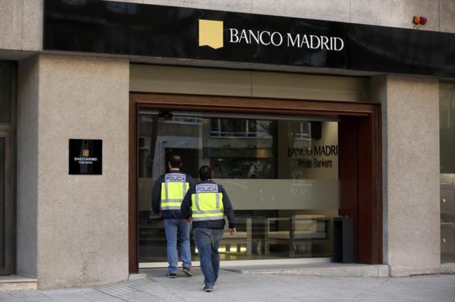 Dos agentes de la Polica entran en una oficina de Banco Madrid tras...