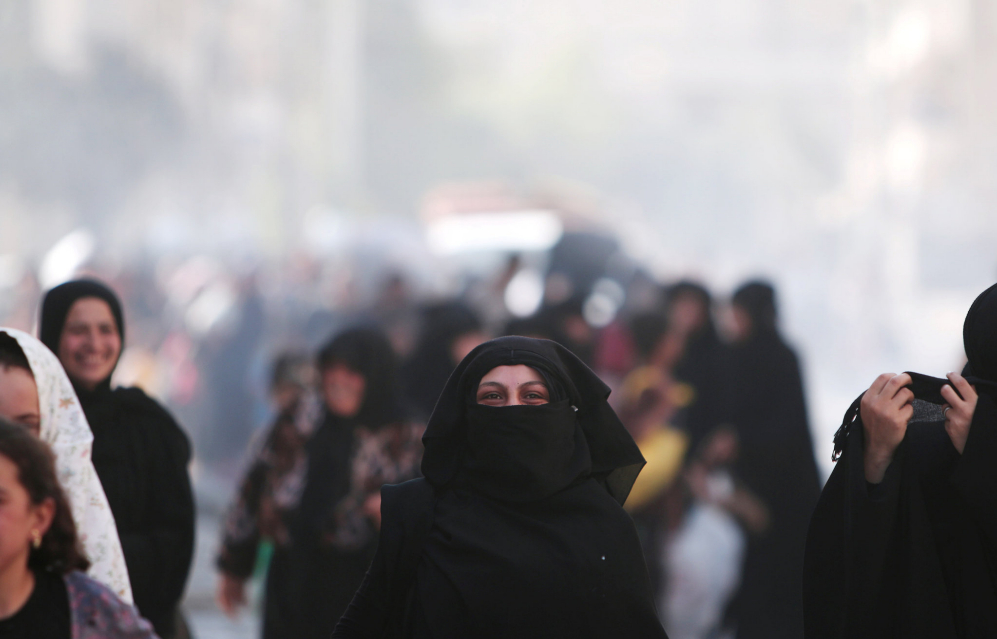 Una mujer camina sonriente tras ser evacuada por las Fuerzas...