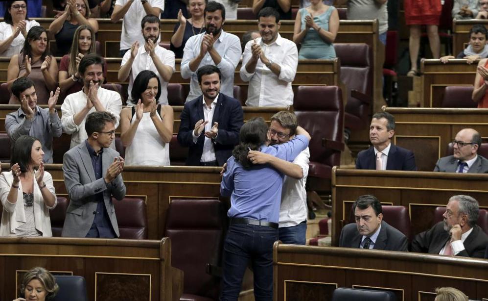 El lder de Podemos, Pablo Iglesias (de espaldas), abraza al portavoz...