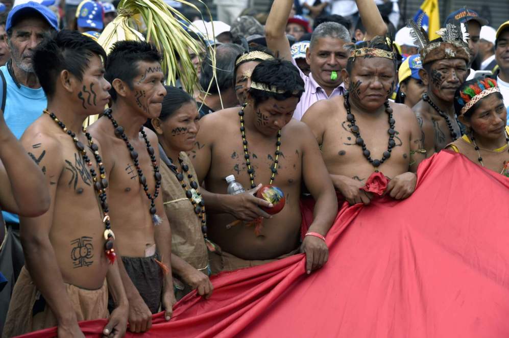 Un grupo de indgenas ondea una bandera venezolana