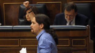 Pablo Iglesias pasa delante de Mariano Rajoy durante el debate de...