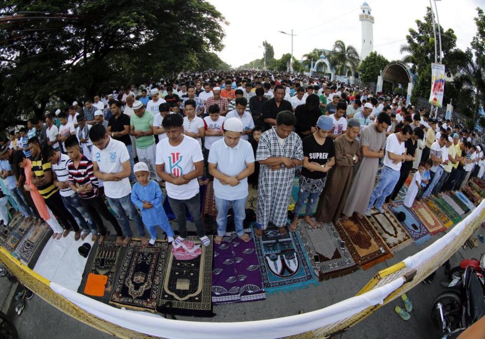 Filipinos musulmanes oran sobre sus alfombras en la ciudad de Taguig,...