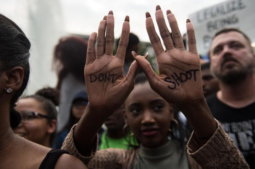 Una manifestante ensea las palmas de sus manos con un lema escrito...