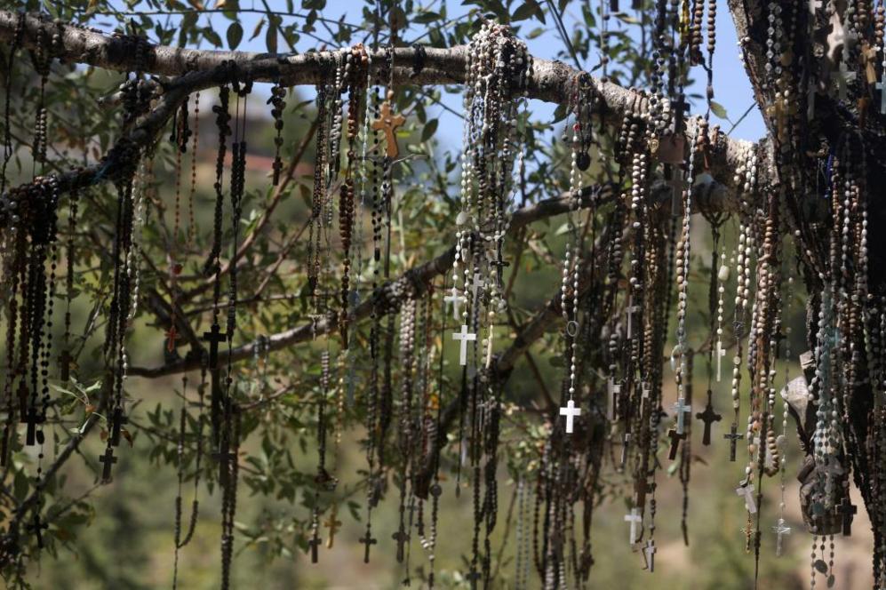 Multitud de rosarios cuelgan de un rbol en el monumento cristiano de...