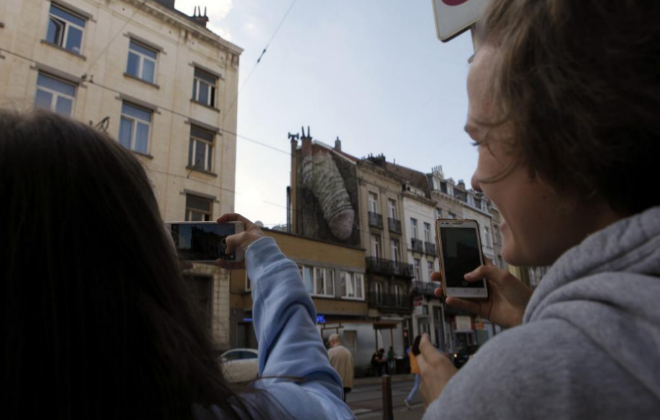 Varias personas fotografan en Bruselas el mural del pene creado en...