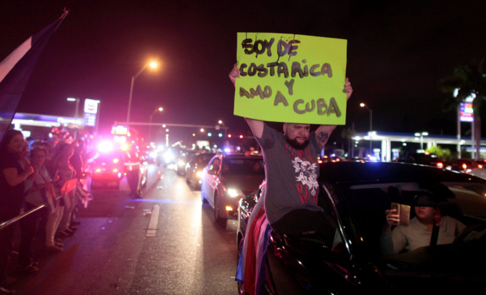 Un hombre celebra la muerte con un cartel que pone: Soy de Costa Rica...