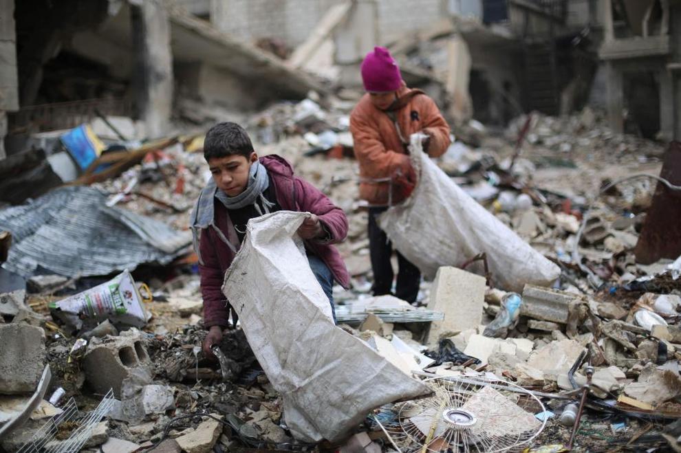 Jvenes sirios recogen madera entre los escombros que utilizarn...
