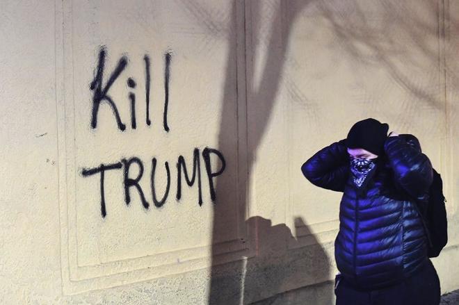 Una mujer camina junto a un grafiti que reza "Matad a Trump"  en Berkely. (EEUU).