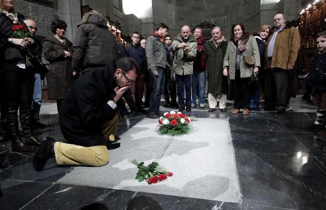Un hombre se arrodilla ante la tumba de Francisco Franco en la...