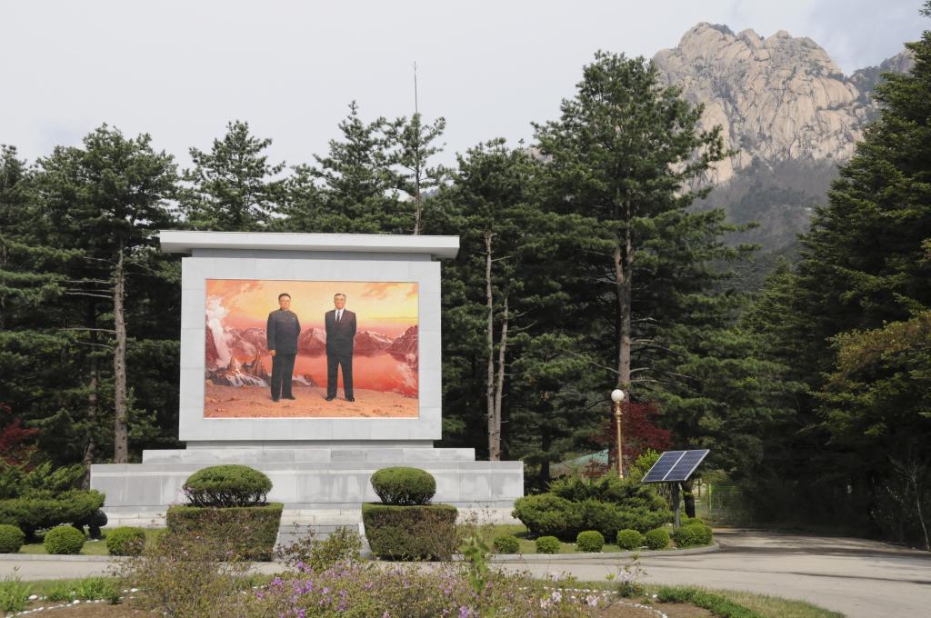 Un mural con los rostros de Kim Il Sung y Kim Jong Il preside las...