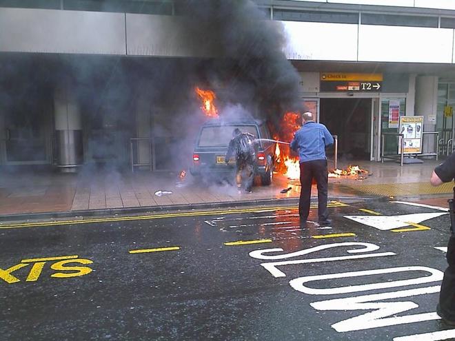 Un polica apaga las llamas tars el ataque del aeropuerto de Glasgow.