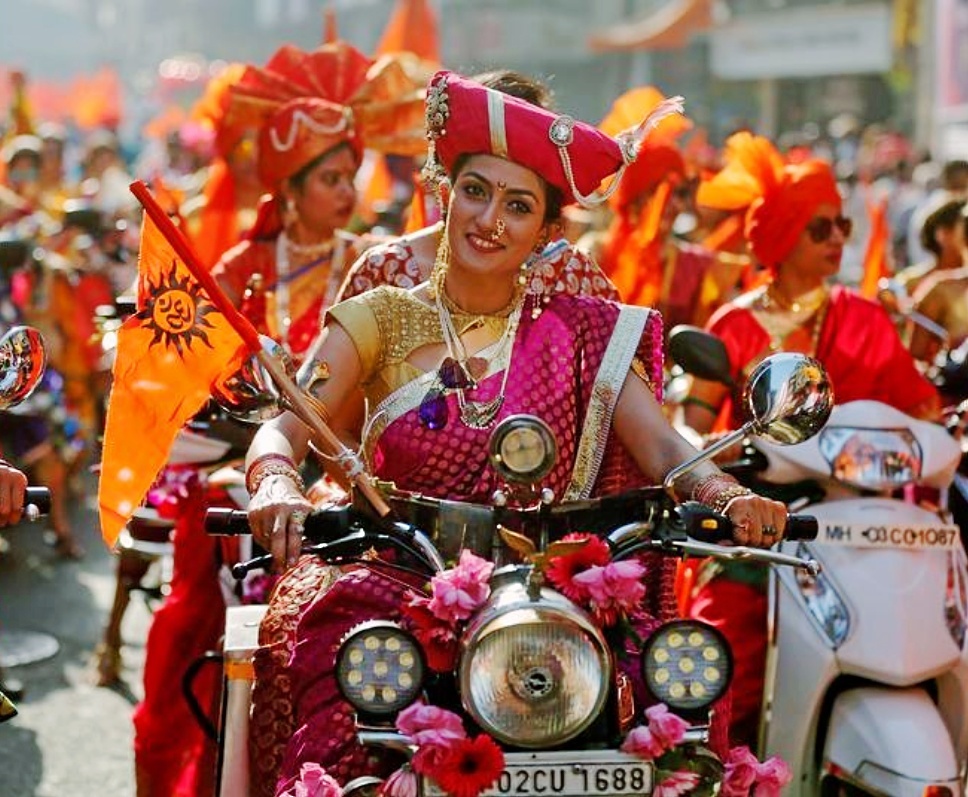Mujeres vestidas con trajes tradicionales, en moto durante un festival en Bombay.