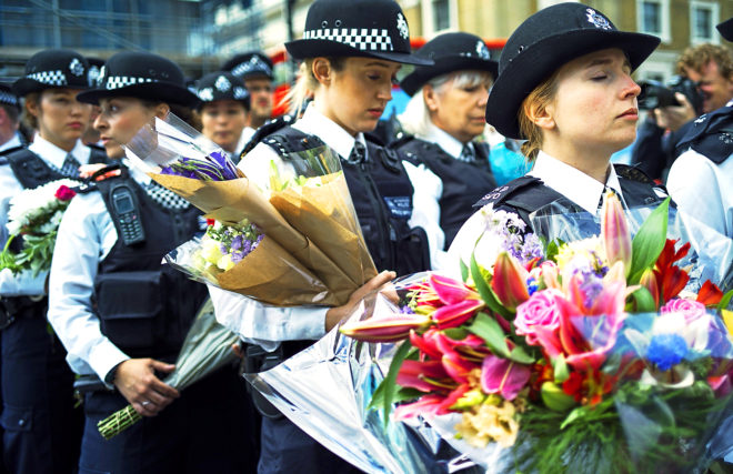Policas britnicos ofrecen flores cerca del lugar de los ataques del London Bridge, ayer.