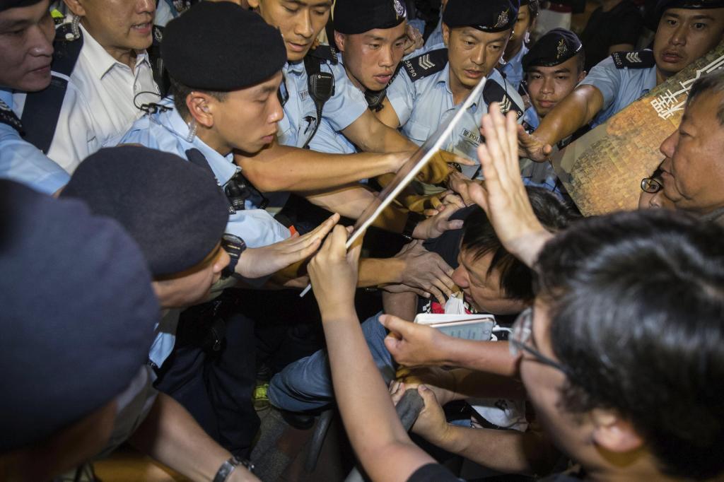 Varios policas controlan a un grupo de manifestantes prodemocracia durante una manifestacin en Hong Kong, este viernes.